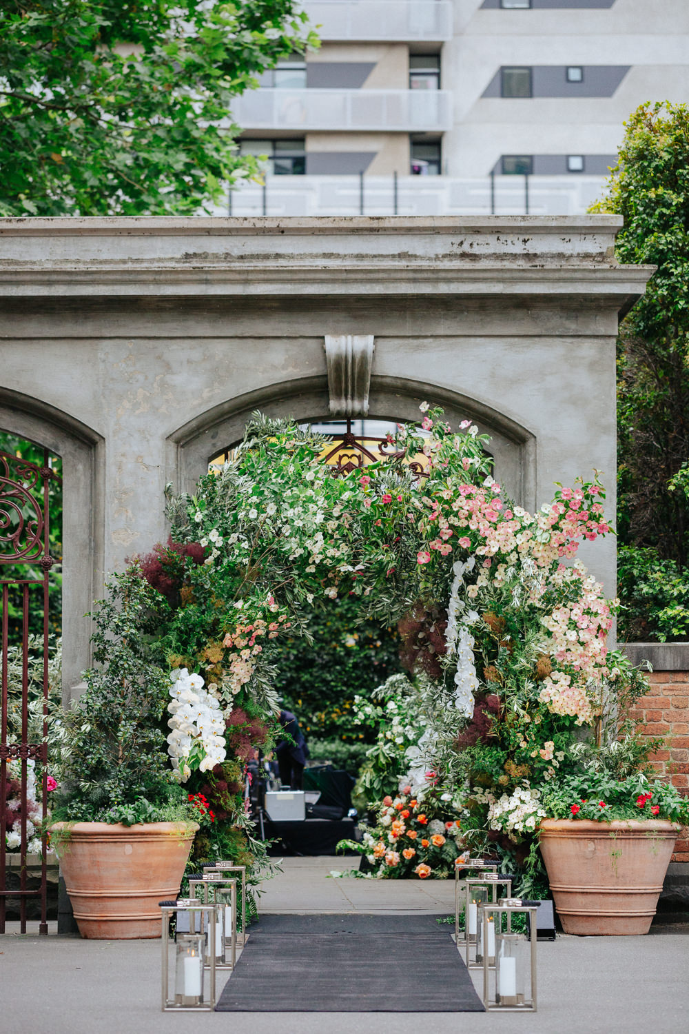 A floral archway in front of a stone archway.