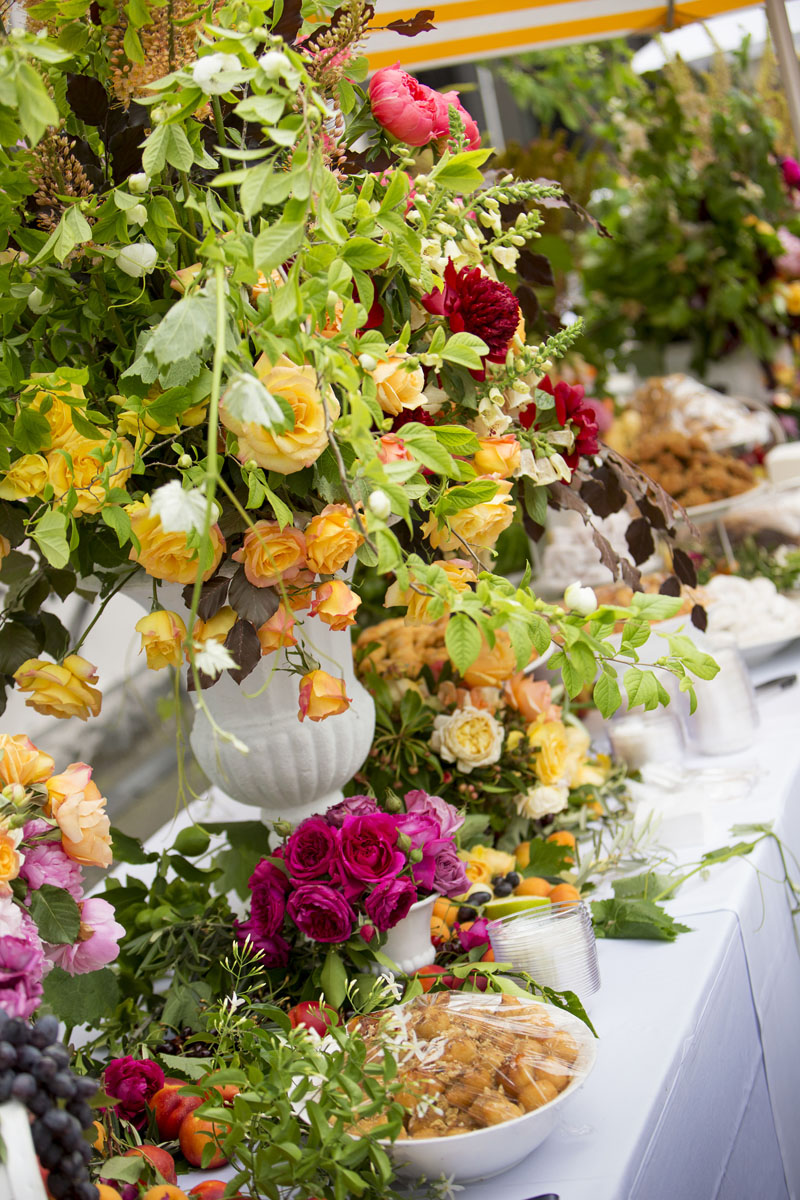 A table of food and colourful flowers.