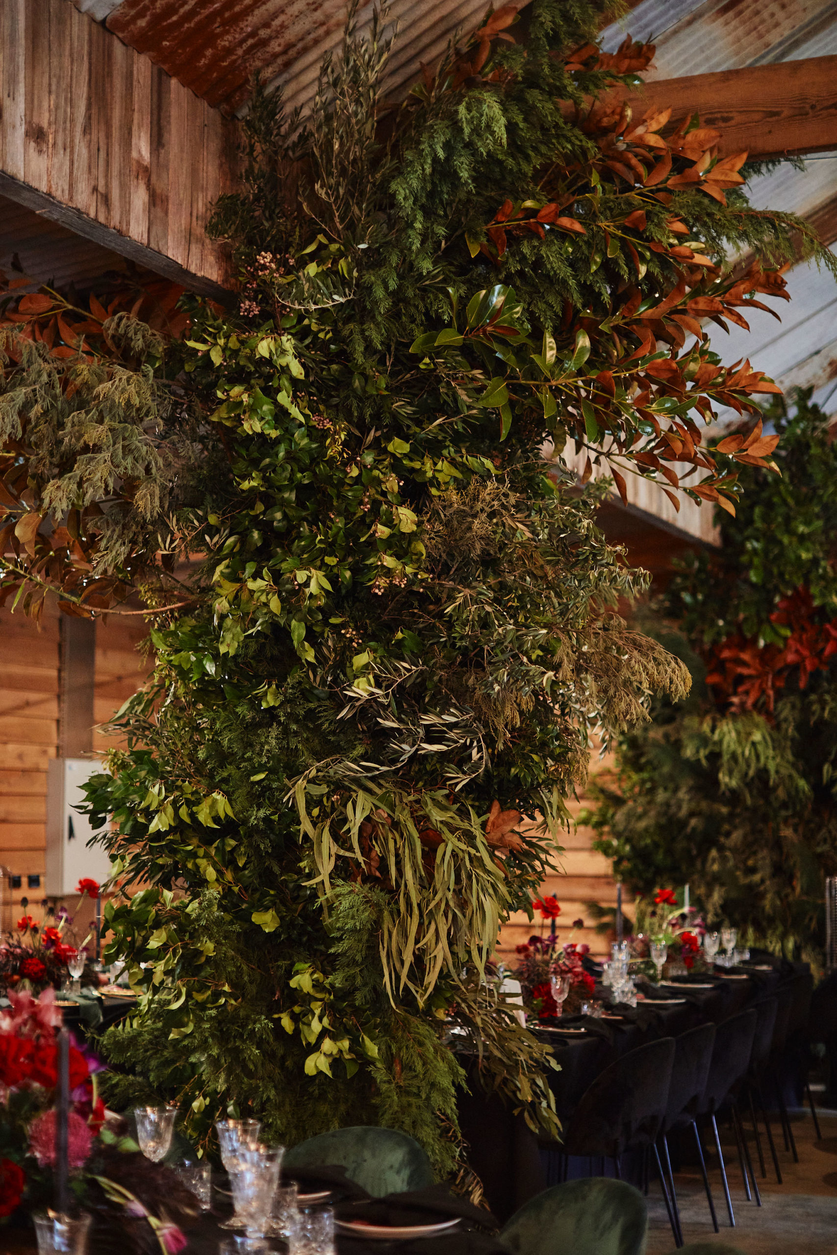 A green leafy foliage installation on the wall of a barn.
