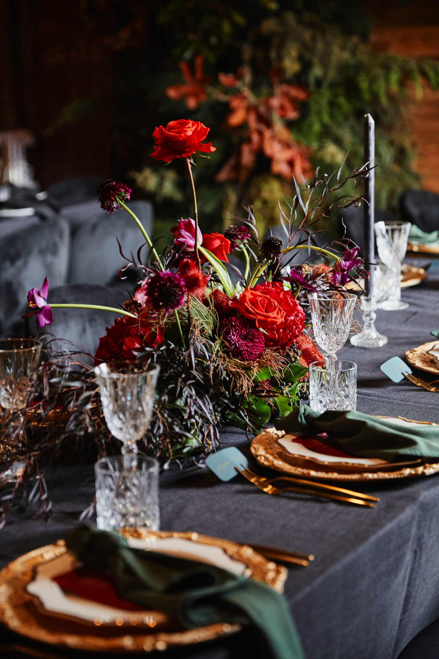 A purple and red floral arrangement on a dining table.